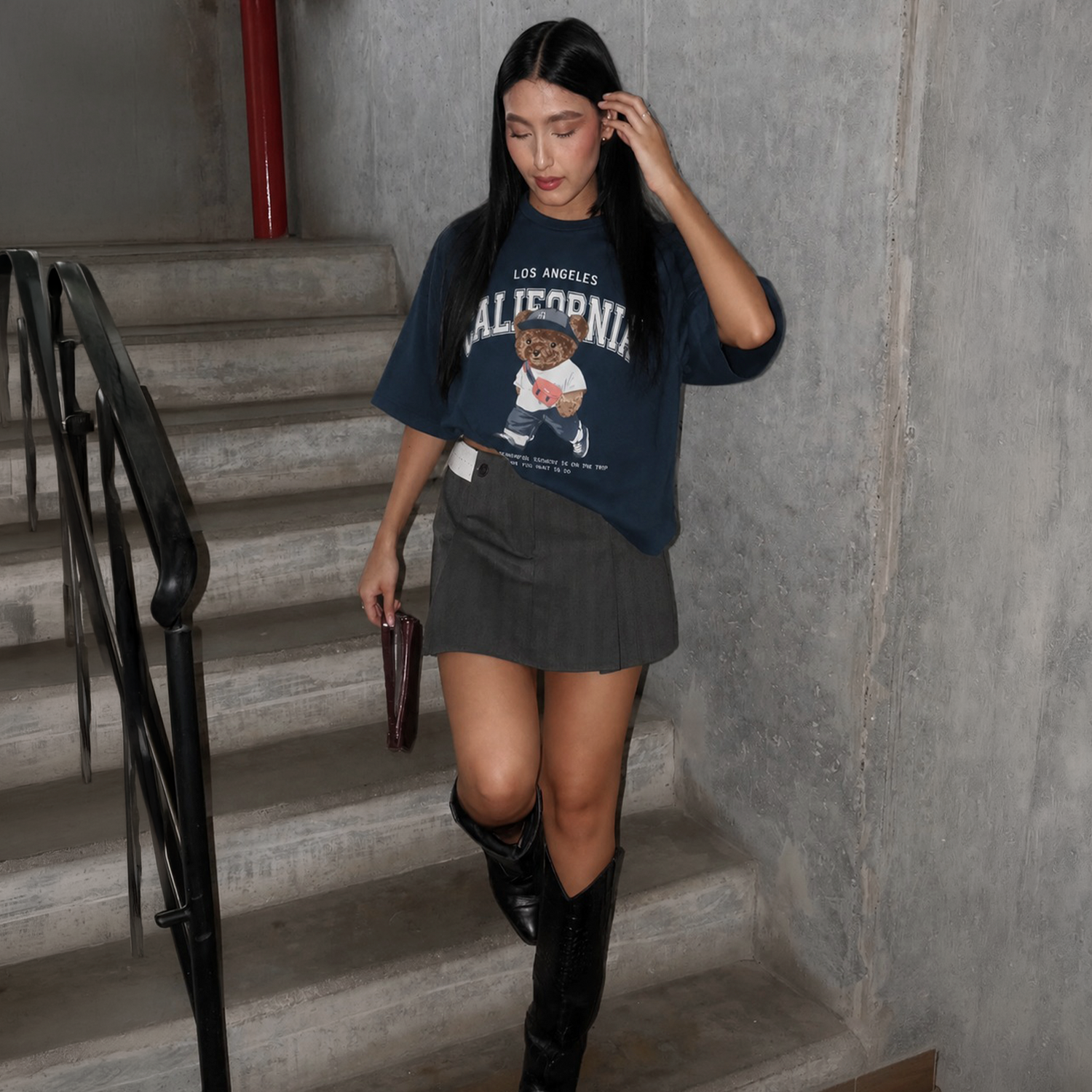 Estilo de calle urbano para MAFA: lookbook de la colección Streetwear Essentials con modelo vistiendo camiseta oversize estampada y botas vaqueras en un entorno industrial con concreto